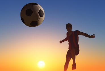 soccer player with ball in sunset